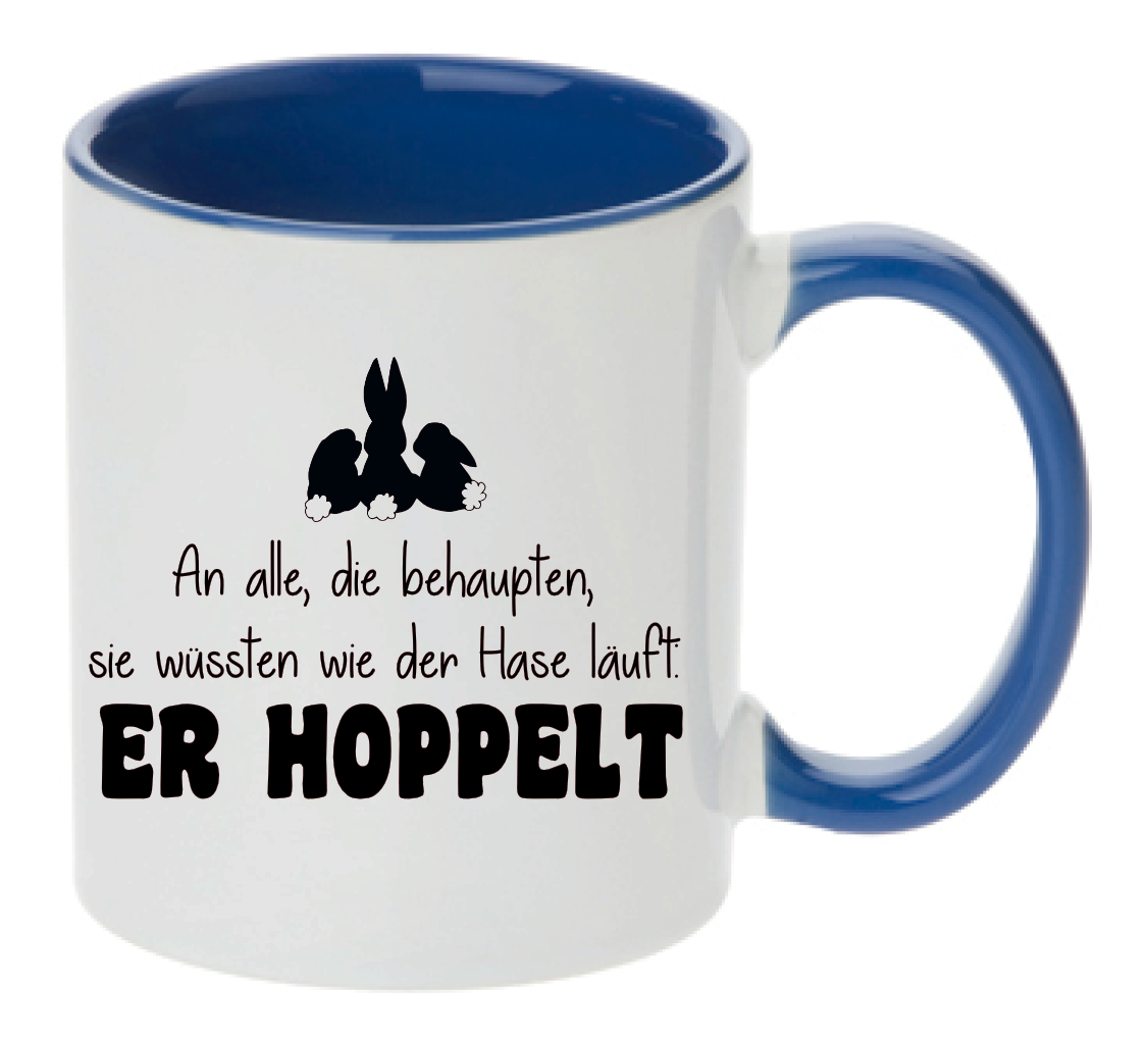 Blaue Tasse mit Spruch An alle, die behaupten, sie wüssten wie der Hase läuft. Er hoppelt und drei Comic Hasen auf der Tasse
