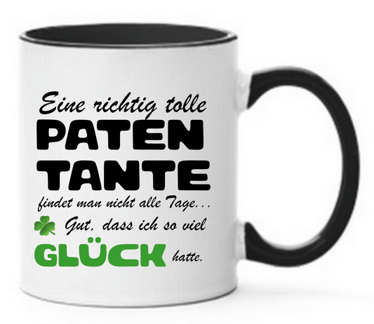 Schwarze Tasse mit dem Spruch Eine richtig tolle Patentante findet man nicht alle Tage... Gut, dass ich so viel Glück hatte. Mit Grünem Kleeblatt und Glück in grün geschrieben