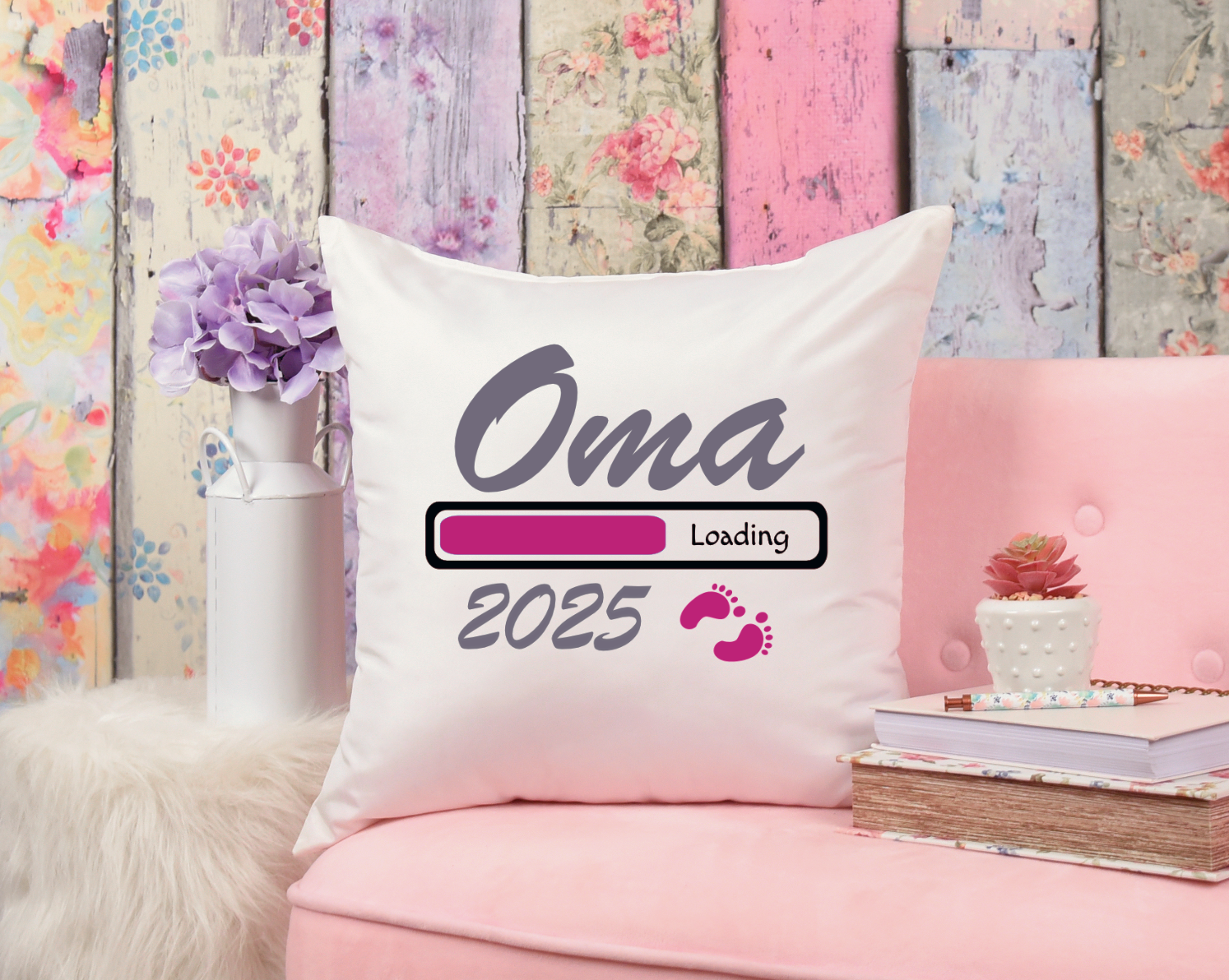 Weißes Kissen mit Aufdruck in pink, schwarz und grau mit dem Text Oma Loading 2025