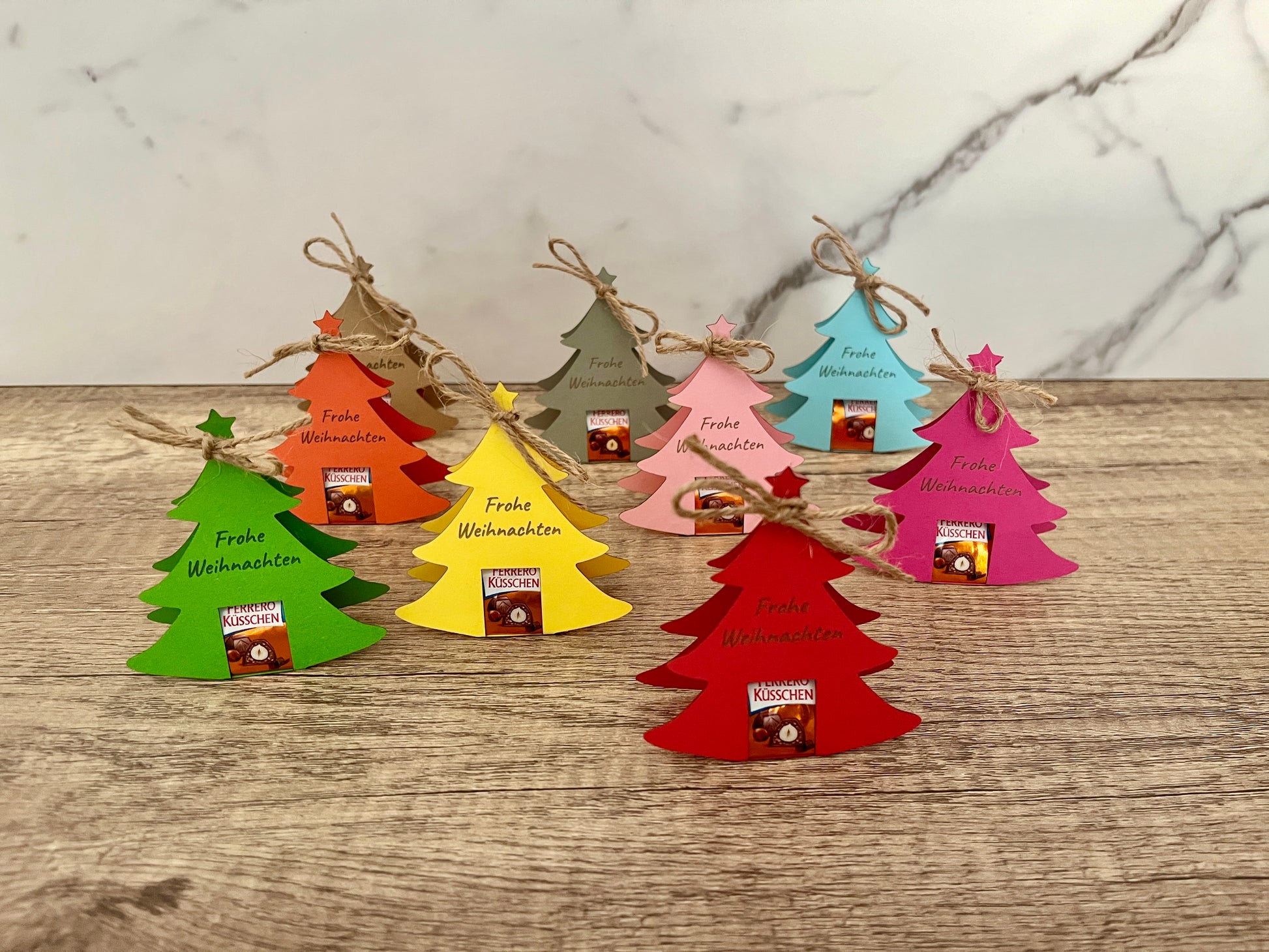 Tannenbaum aus Karton in verschiedenen Farben, es passen perfekt kleine Ferrero Küsschen hinein, auf dem Tannenbaum steht entweder Frohe Weihnachten oder der Wunschtext. Farben in rosa, pink, blau, grau, braun, orange, gelb und grün möglich.