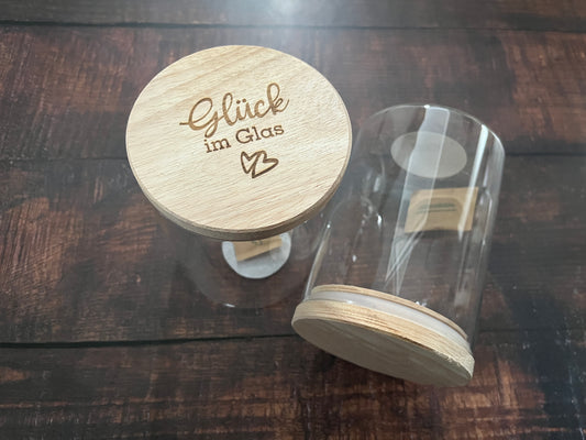 Vorratsglas aus durchsichtigem Glas mit Holzdeckel. Hier mit der Gravur Glück im Glas und Herzen